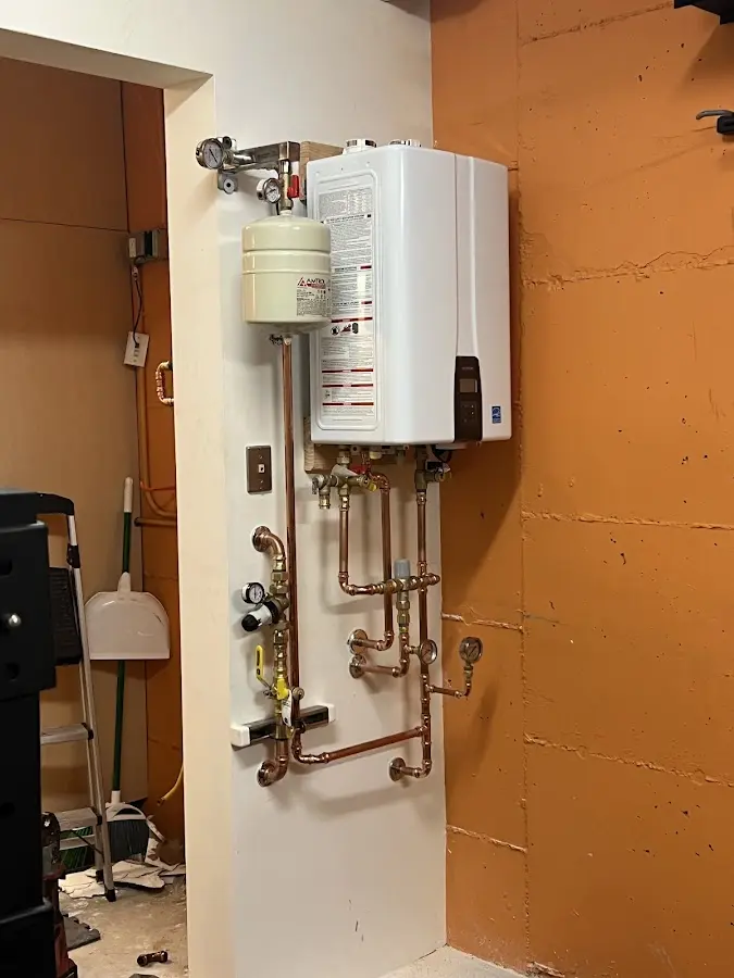 Plumbing technician inspecting water heater connections in Calera